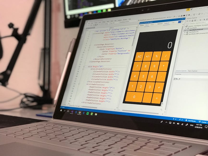 A close-up view of a person's hands operating a sleek laptop on a dark, reflective surface, with the screen displaying lines of code in a dark mode interface. The background is blurred, highlighting t